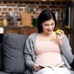 depositphotos 187717898 stock photo smiling young pregnant woman eating